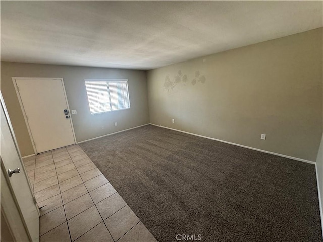 tiled spare room with baseboards and carpet