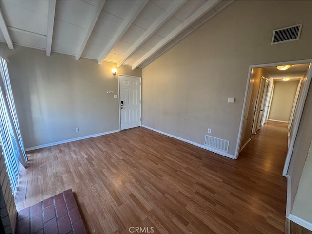 unfurnished room featuring beam ceiling, visible vents, baseboards, and wood finished floors