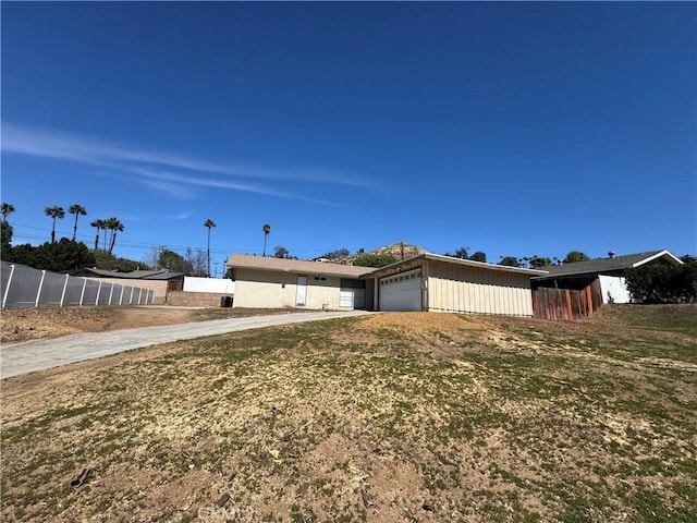 view of front of property featuring a garage and fence