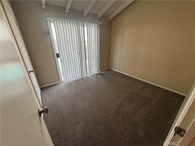 carpeted spare room with vaulted ceiling with beams and baseboards