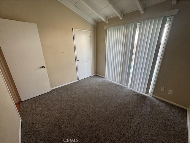 carpeted spare room featuring lofted ceiling with beams and baseboards