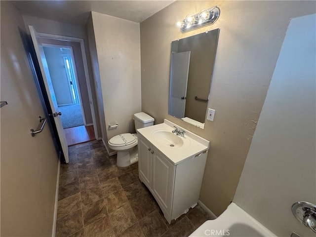 bathroom featuring vanity, toilet, and baseboards