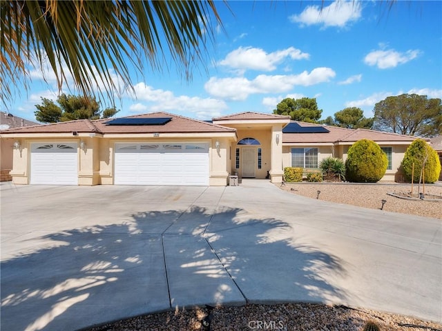 view of front of house with solar panels, concrete driveway, a garage, and stucco siding