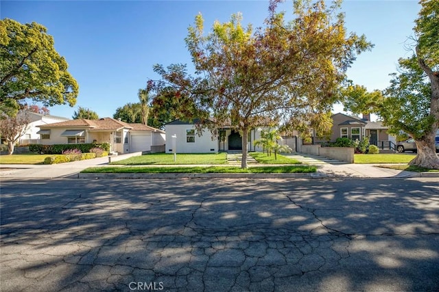 view of front of property with driveway, an attached garage, and a front yard