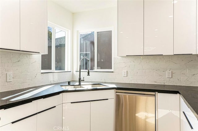 kitchen featuring a sink, backsplash, dishwasher, white cabinetry, and modern cabinets