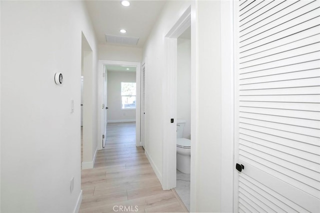 hall with recessed lighting, light wood-type flooring, baseboards, and visible vents