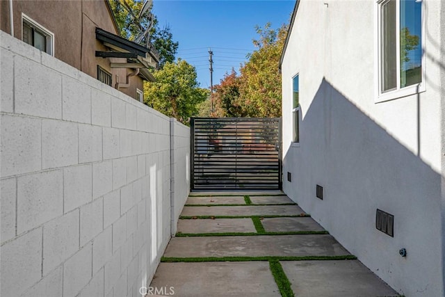 view of side of property featuring stucco siding and fence