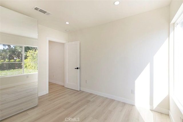 spare room with light wood finished floors, visible vents, recessed lighting, and baseboards