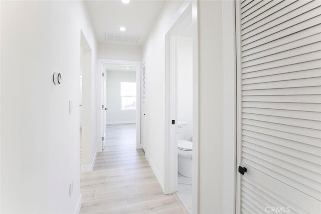 corridor with recessed lighting, visible vents, baseboards, and light wood-style flooring