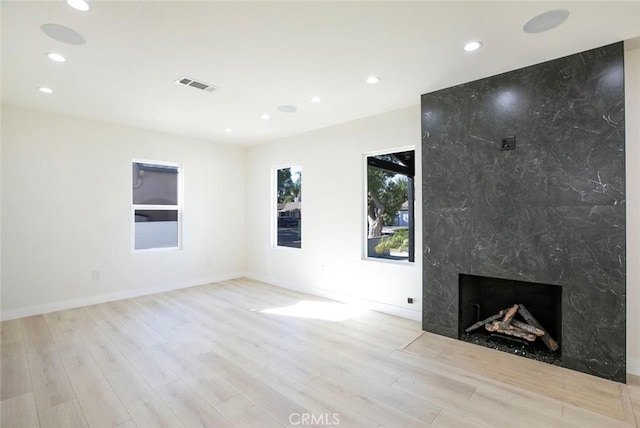 unfurnished living room featuring visible vents, recessed lighting, a fireplace, and wood finished floors