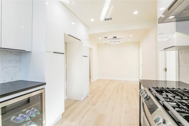 kitchen featuring modern cabinets, white cabinets, beverage cooler, and visible vents