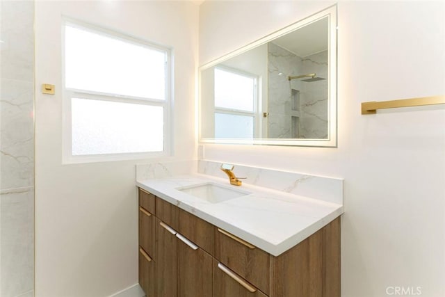 full bathroom featuring a marble finish shower and vanity