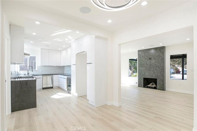 kitchen featuring modern cabinets, light wood-style flooring, open floor plan, white cabinets, and dishwasher