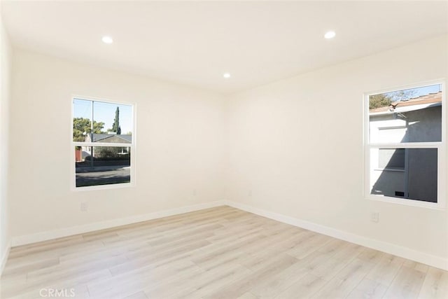 spare room with recessed lighting, baseboards, and light wood-style floors