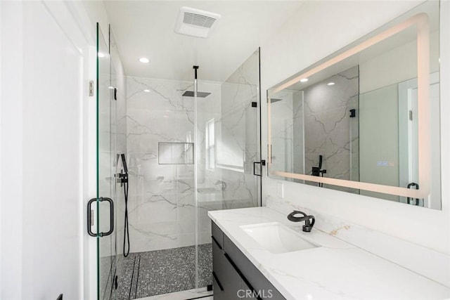 full bathroom featuring a marble finish shower, visible vents, recessed lighting, and vanity