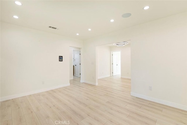 empty room featuring light wood-style flooring, recessed lighting, and visible vents