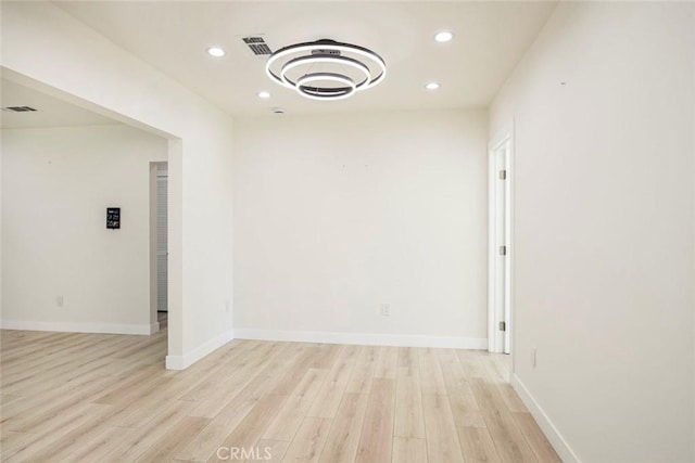 spare room featuring visible vents, recessed lighting, light wood-type flooring, and baseboards