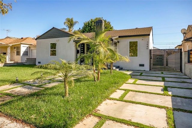 back of house with a lawn and stucco siding