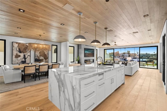 20 Balboa Cvs, Newport Beach, CA 92663 - kitchen with wood ceiling, open floor plan, light wood-style flooring, light stone countertops, and white cabinetry