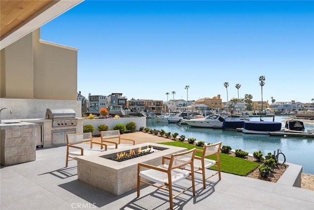 20 Balboa Cvs, Newport Beach, CA 92663 - view of patio / terrace featuring an outdoor kitchen, a sink, area for grilling, a water view, and a fire pit