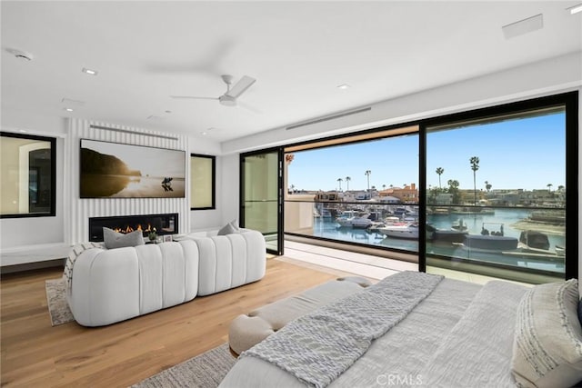 20 Balboa Cvs, Newport Beach, CA 92663 - bedroom with ceiling fan, a glass covered fireplace, visible vents, a water view, and wood finished floors