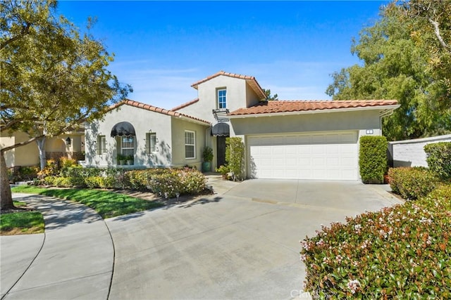 mediterranean / spanish-style house with stucco siding, an attached garage, a tile roof, and driveway