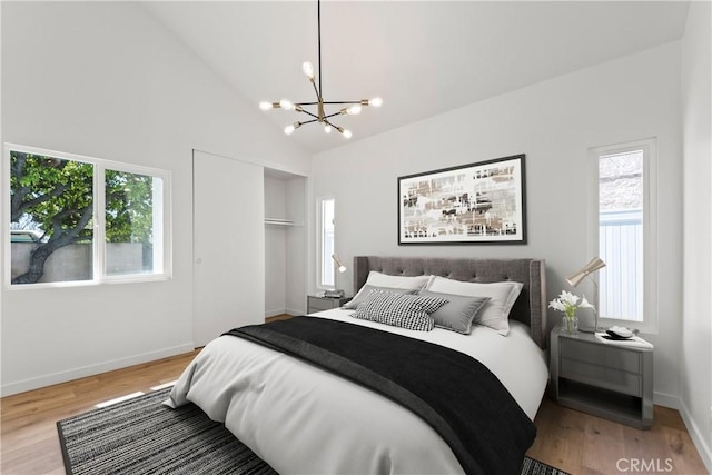 bedroom featuring multiple windows, lofted ceiling, and wood finished floors