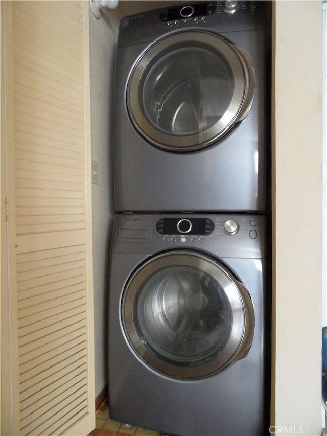 laundry area with stacked washer / drying machine and laundry area