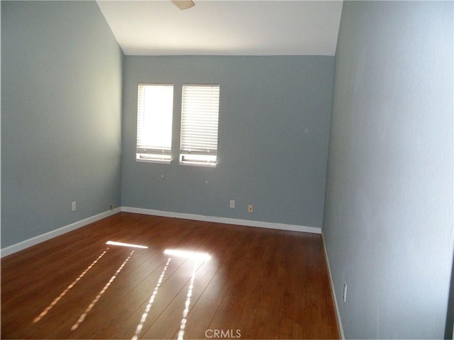 unfurnished room featuring baseboards and wood finished floors