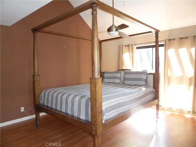 bedroom featuring baseboards, wood finished floors, ceiling fan, and vaulted ceiling