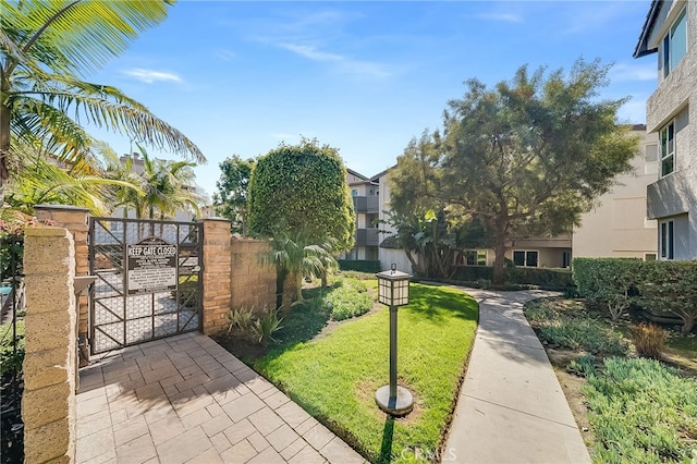 surrounding community featuring a yard, fence, and a gate