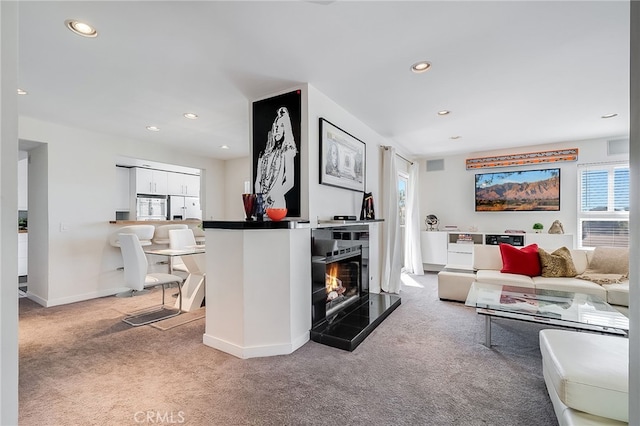 carpeted living room featuring a fireplace, recessed lighting, and baseboards