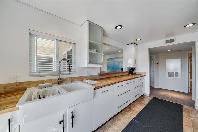 kitchen featuring visible vents, recessed lighting, a sink, butcher block countertops, and white cabinets