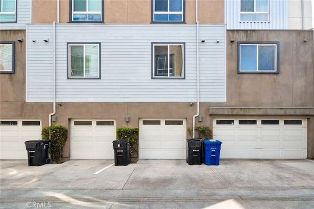 exterior space with an attached garage, driveway, and stucco siding