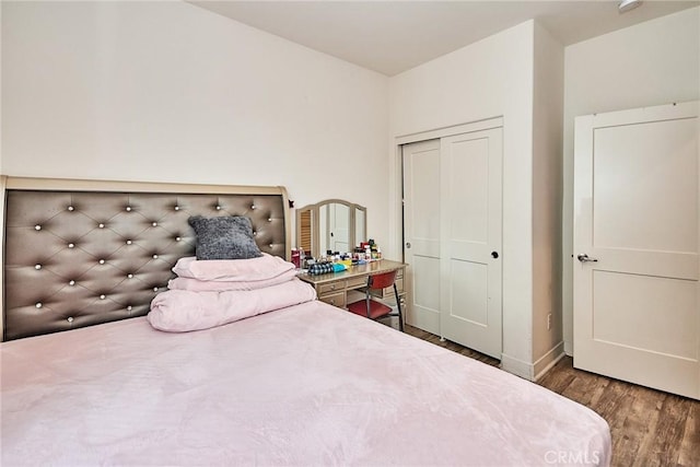 bedroom featuring a closet, baseboards, and wood finished floors