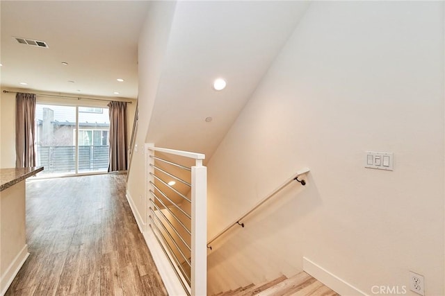 stairway with recessed lighting, visible vents, baseboards, and wood finished floors