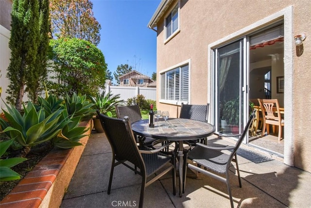 view of patio featuring outdoor dining space and fence