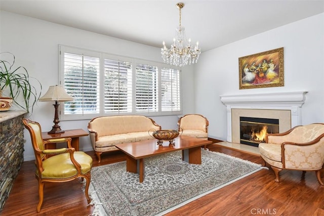 living area featuring a chandelier, wood finished floors, and a high end fireplace