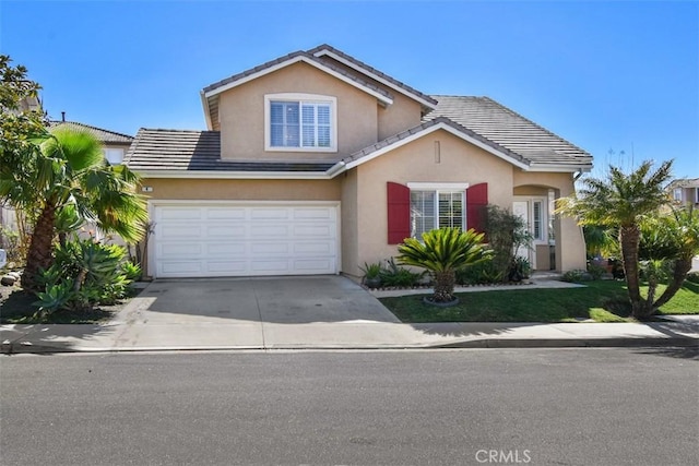 traditional-style home with stucco siding, a garage, driveway, and a tile roof