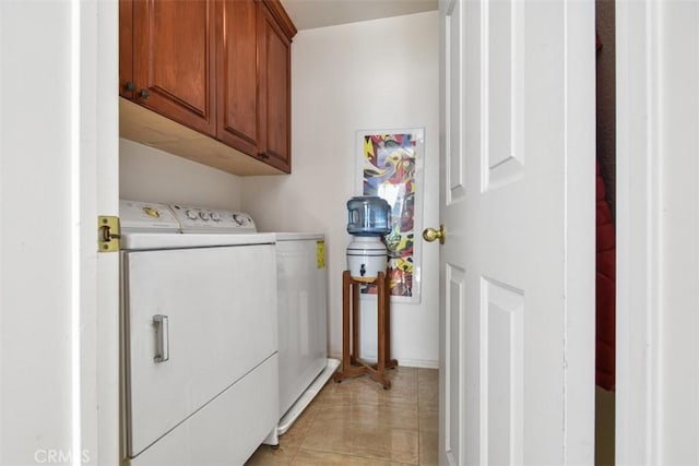 laundry area with light tile patterned floors, cabinet space, and separate washer and dryer