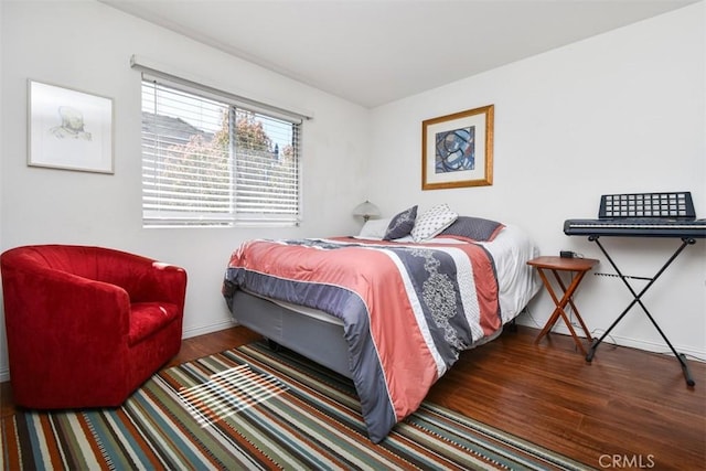 bedroom featuring baseboards and wood finished floors