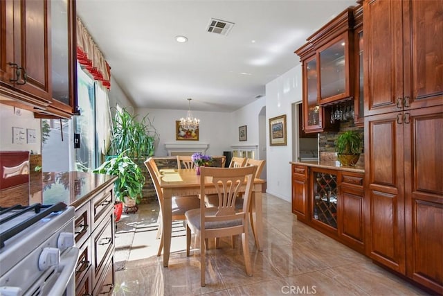 dining area with an inviting chandelier, recessed lighting, visible vents, and arched walkways