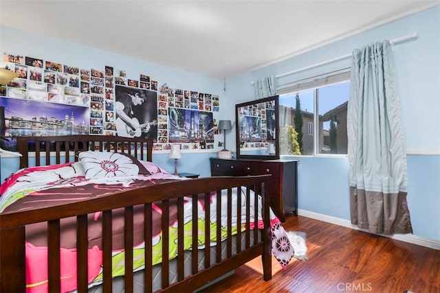 bedroom featuring baseboards and wood finished floors