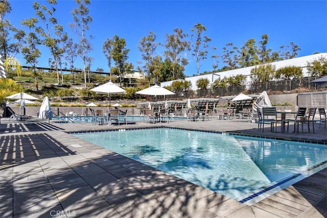 pool with a patio and fence