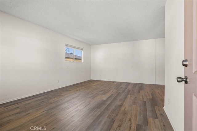 empty room with a textured ceiling and wood finished floors