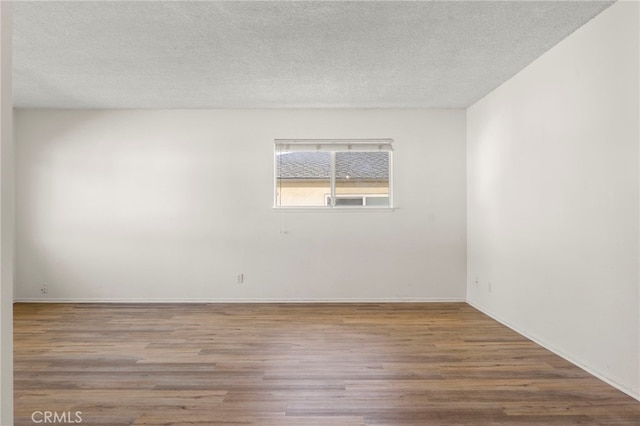 unfurnished room featuring a textured ceiling and wood finished floors