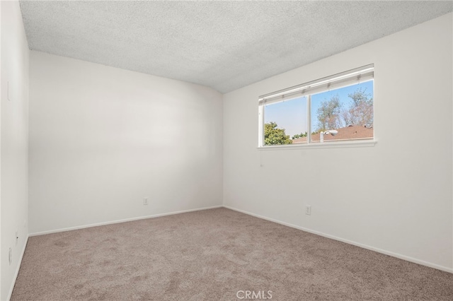 carpeted empty room with baseboards and a textured ceiling