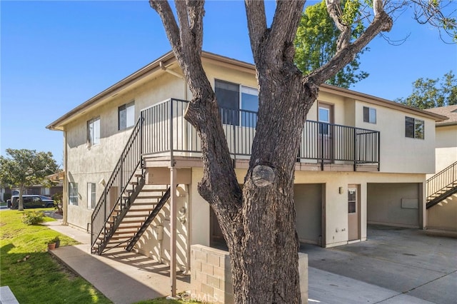 view of front of home with stucco siding and stairway