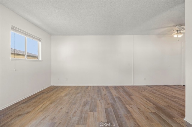 spare room with ceiling fan, a textured ceiling, and wood finished floors