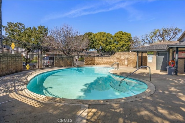 community pool featuring a patio and fence